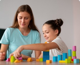 An occupational therapist building with blocks alongside a child